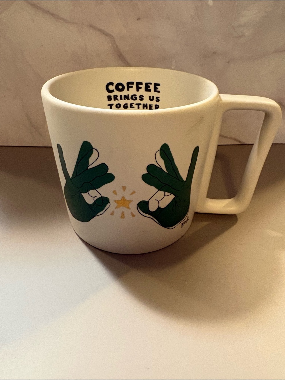 Starbucks White Mug with Green Hand Graphic and Gold Star